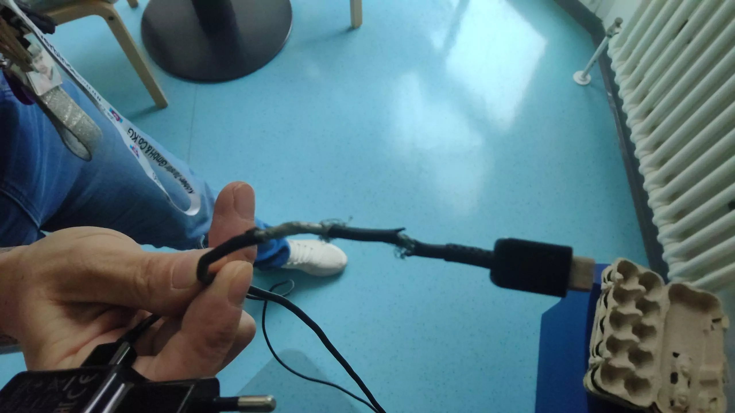 Ein Handyladekabel mit stark ausgefranster Isolierung, Metall des Kabels ebenfalls geknickt