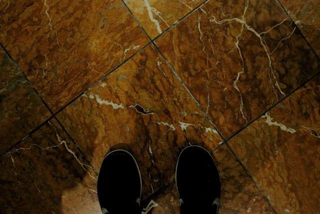 Foto von @jjames25 auf Unsplash: Schwarze Schuhe auf rotem Marmorboden