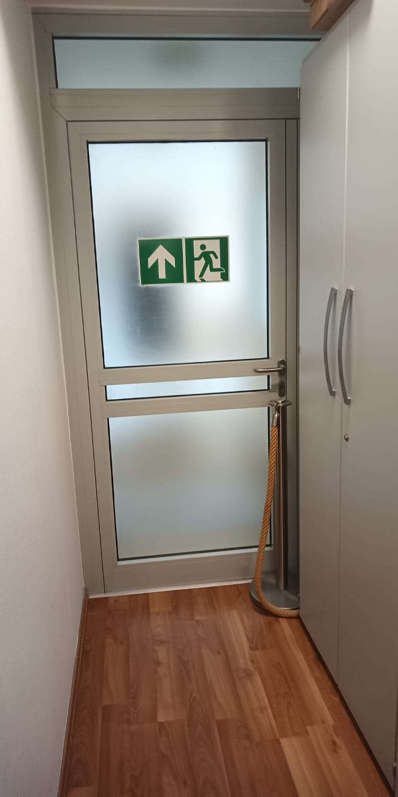 Fluchtwegstür. Daneben steht ein Kordelständer