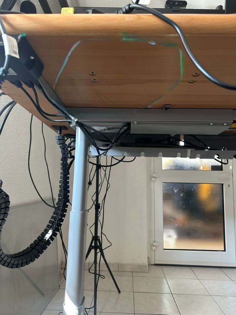 Unterseite eines Schreibtisches mit Kabelkanal und -brücke