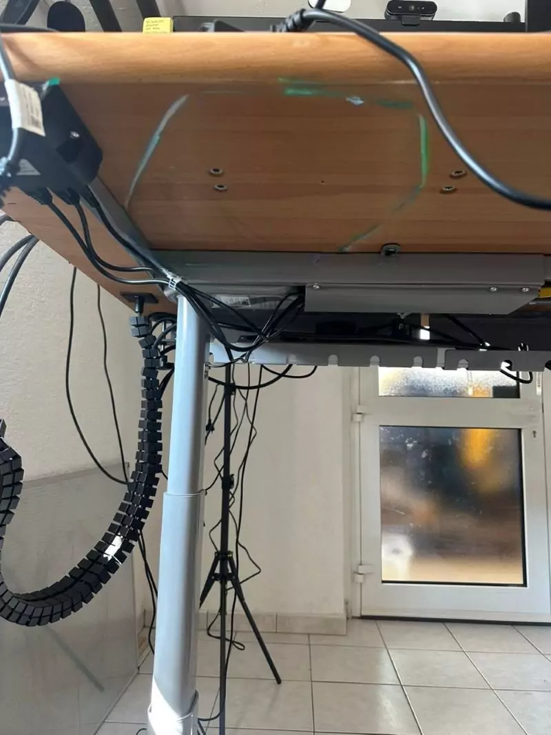 Unterseite eines Schreibtisches mit Kabelkanal und -brücke